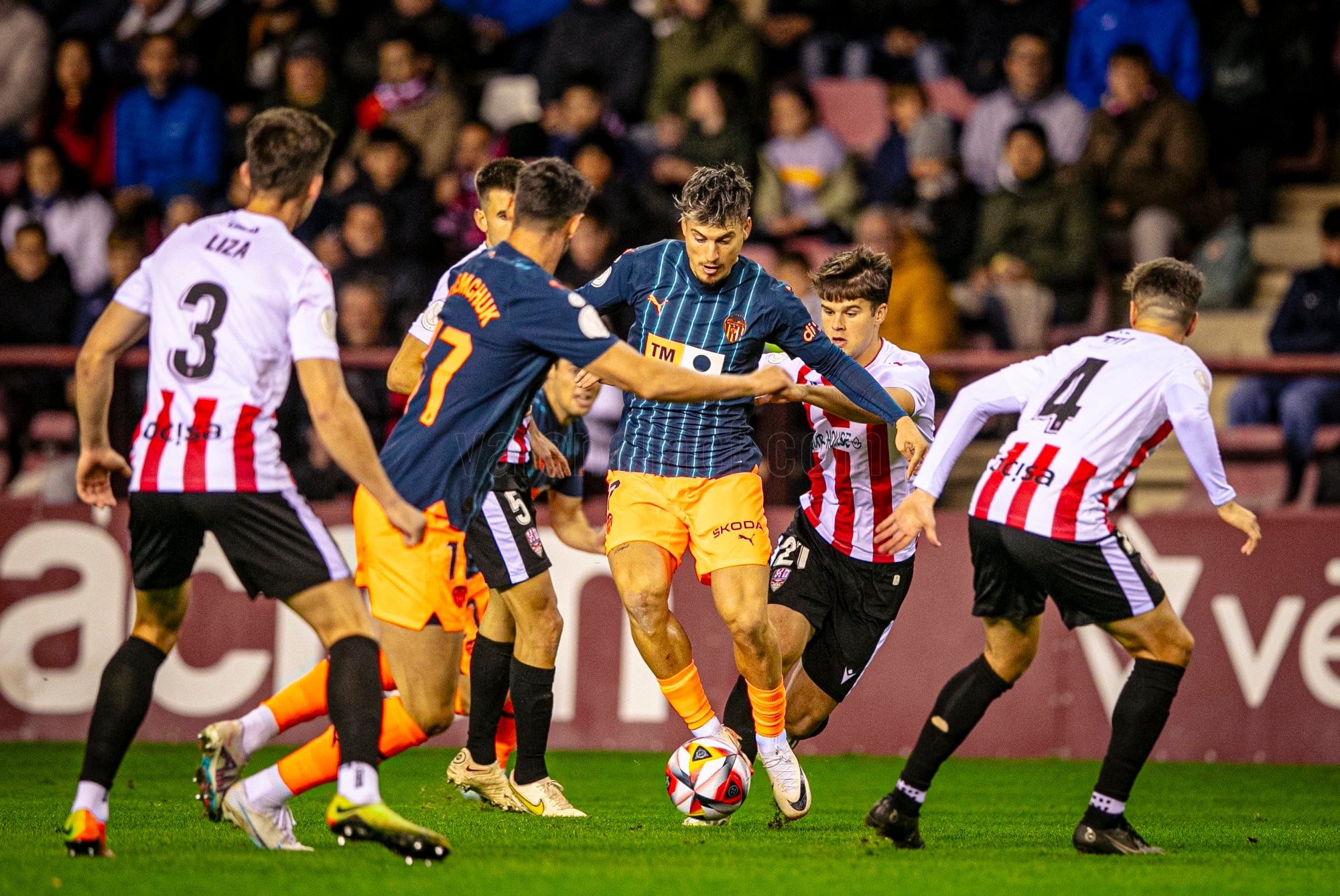 Sergi Canós conduce el balón ante la mirada de varios futbolistas blanquirrojos / Valencia CF