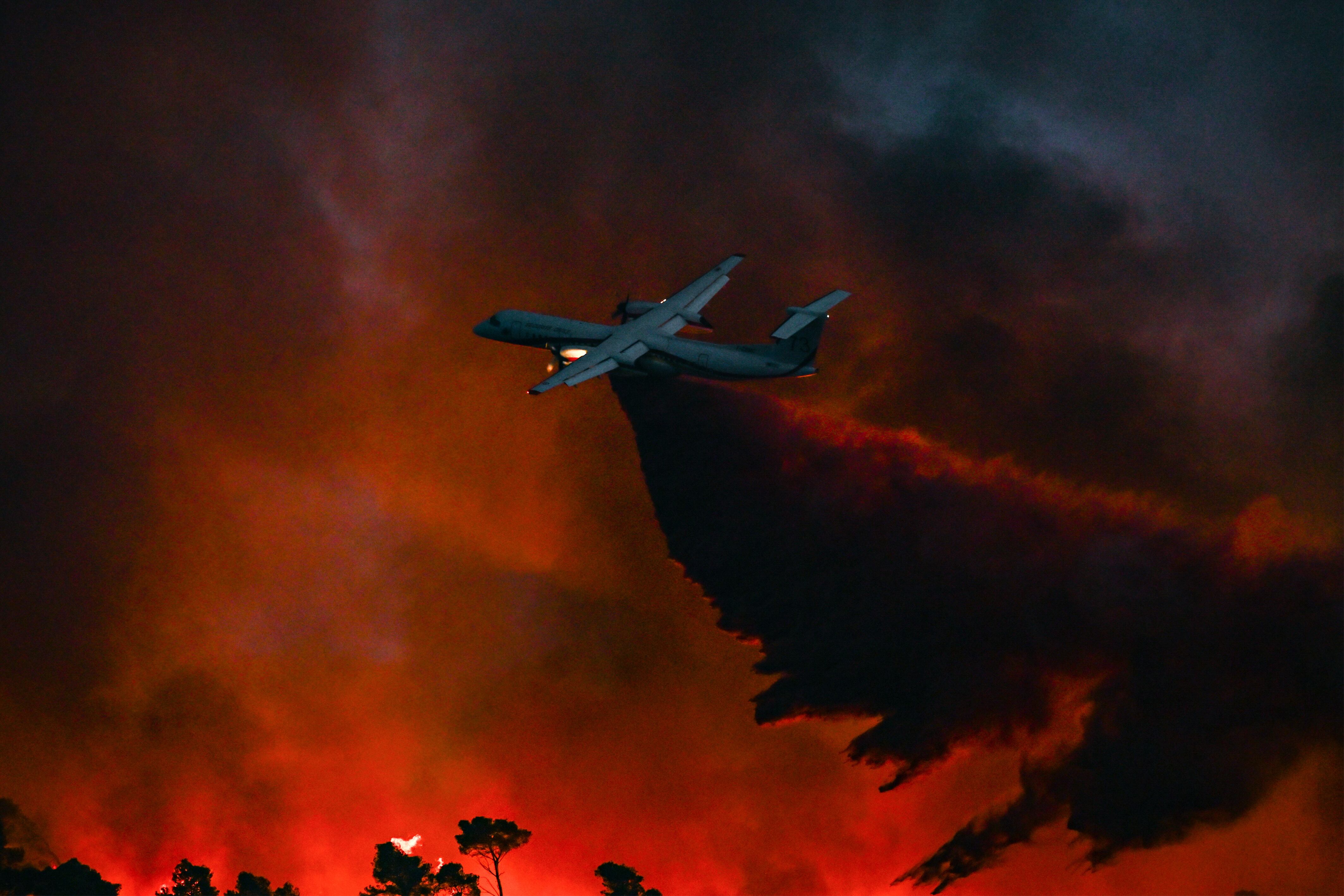 Un avión preparado para la extinción de incendios sobrevuela el fuego que ha arrasado con más de 16.000 hectáreas al sur de Francia.