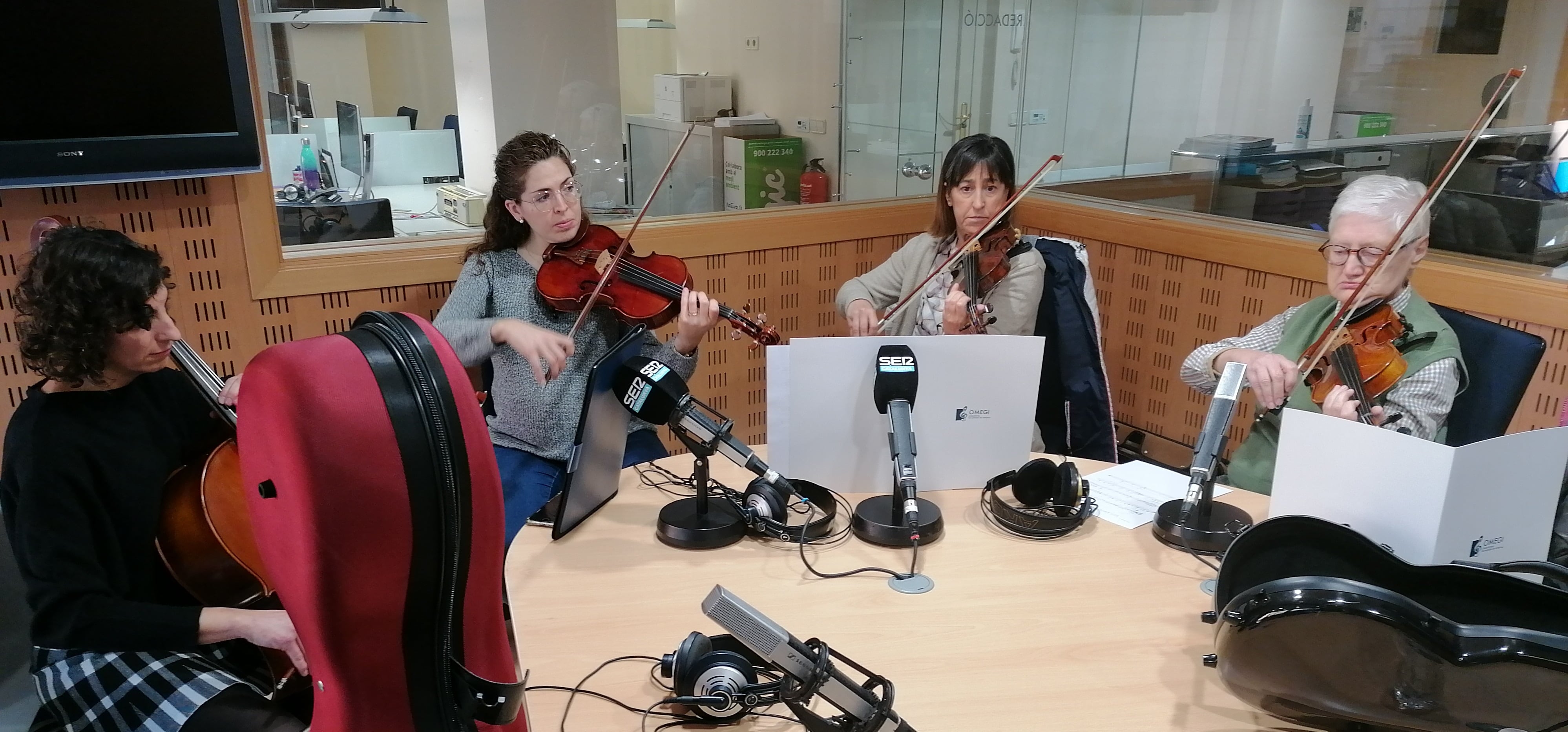 Quatre intèrprets de l'OMEGI als estudis de Ràdio Girona.