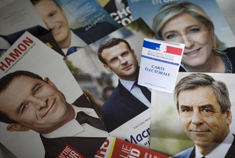 Una credencial para votar es fotografiada sobre los panfletos de los once candidatos para las presidenciales francesas en París