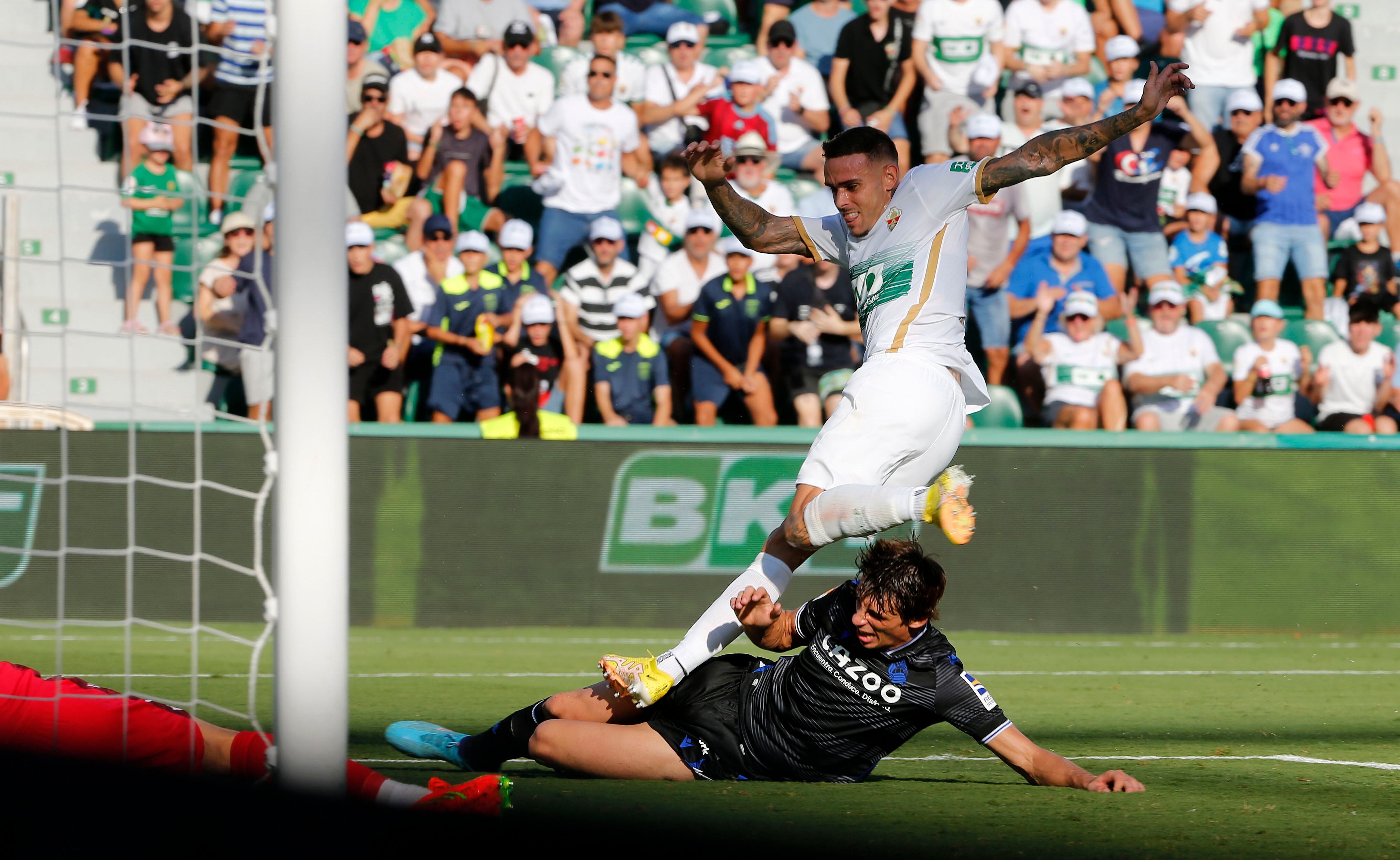 ELCHE, 27/08/2022.- El delantero del Elche Roger Martí (arriba) dispara a puerta junto al francés Le Normand, de la Real Sociedad, durante el partido de la jornada 3 de LaLiga Santander, este sábado en el estadio Martínez Valero, Elche. EFE/Manuel Lorenzo