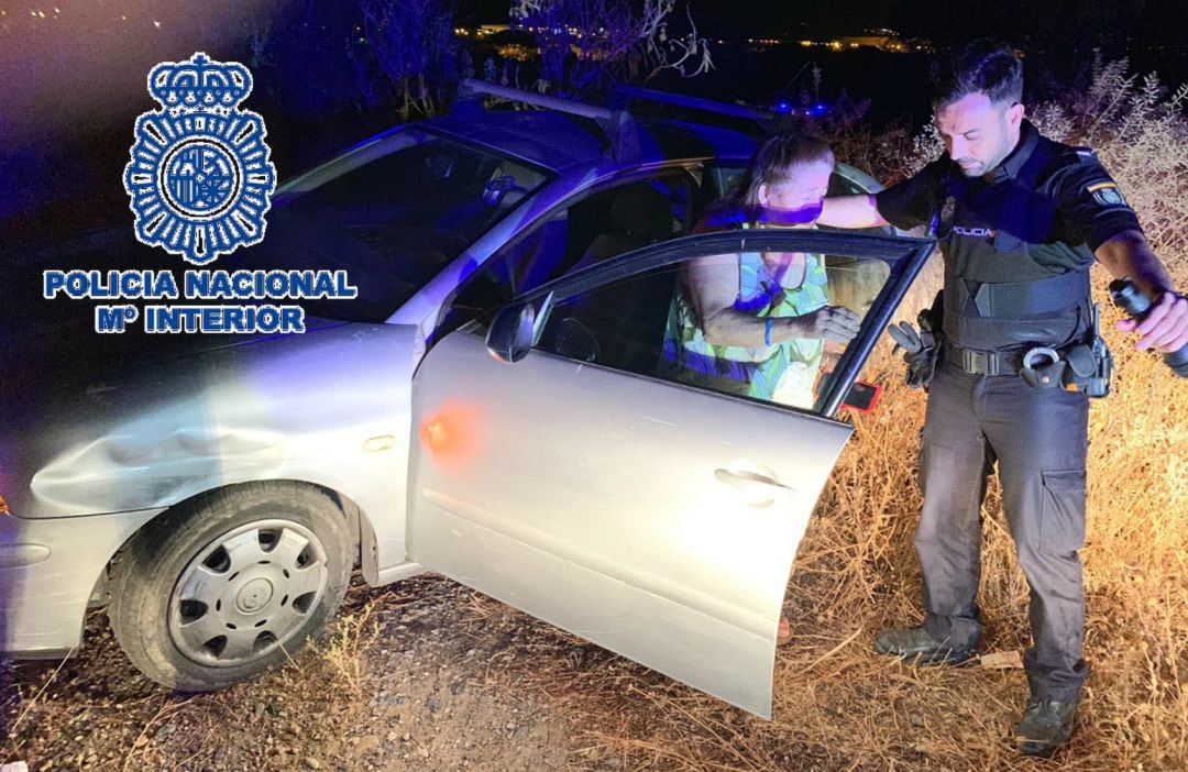 Uno de los agentes ayudando a la mujer a salir del vehículo