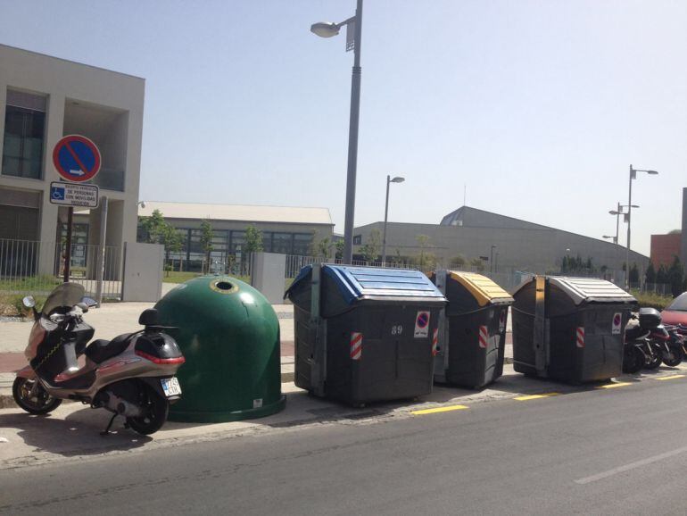 Contendores de basura invaden (y además mal puestos) una zona reservada para aparcamiento de personas con discapacidad en el PTS de Granada