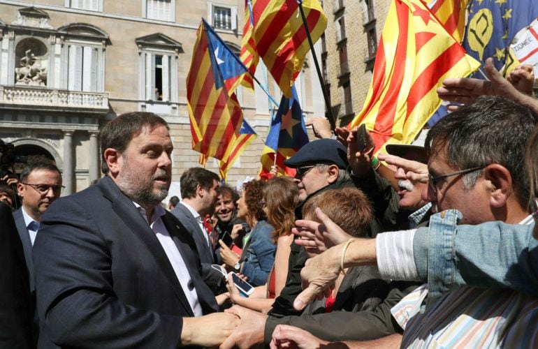 El vicepresidente del Gover, Oriol Junqueras, saluda a un grupo de manifestantes en la Plaza de Sant Jaume de Barcelona.