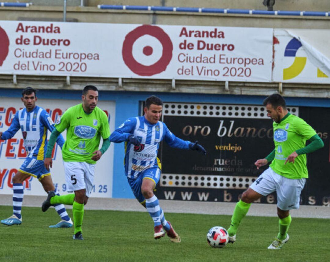 Álex Mozo (centro) pugna por un esférico en el encuentro de la 1ª vuelta en El Montecillo.