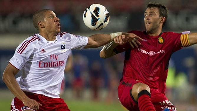 El delantero del RCD Mallorca, Víctor Casadesús, lucha la pelota aérea con el defensa holandés del Hamburgo, Jeffrey Bruma, durante el partido correspondiente al Trofeo Ciudad de Palma disputado en el estadio Iberostar de Palma de Mallorca.