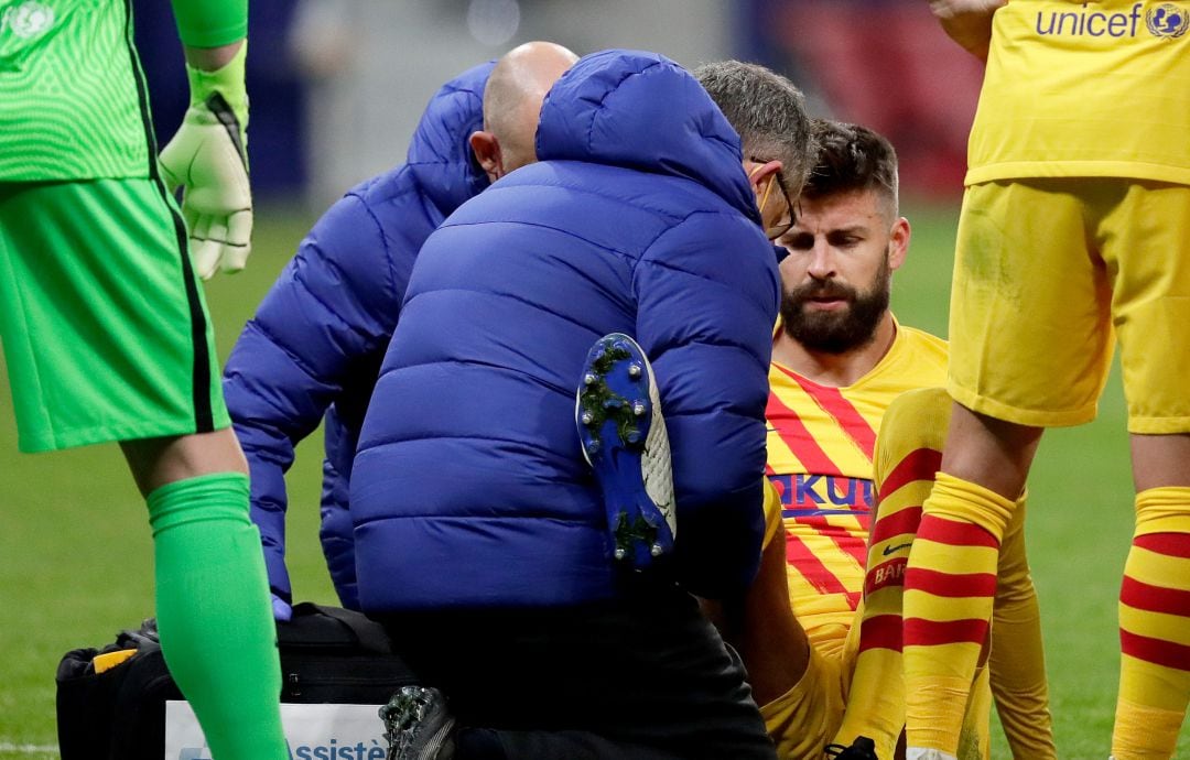 Piqué es atendido por los servicios médicos del Barça en el césped del Wanda Metropolitano