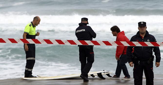La policía inspecciona la tabla de surf de uno de los surfistas fallecidos en la localidad guipuzcoana de Zarautz.