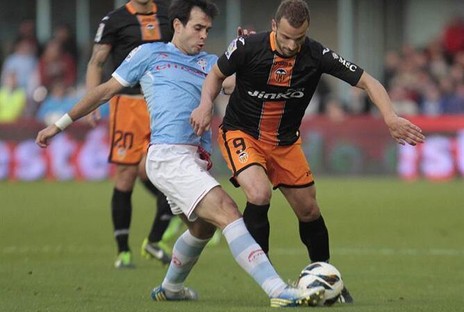 El centrocampista del Celta de Vigo Borja Oubiña y el delantero del Valencia Roberto Soldado luchan por el balón durante el partido correspondiente a la vigésimo tercera jornada de Liga de Primera División.