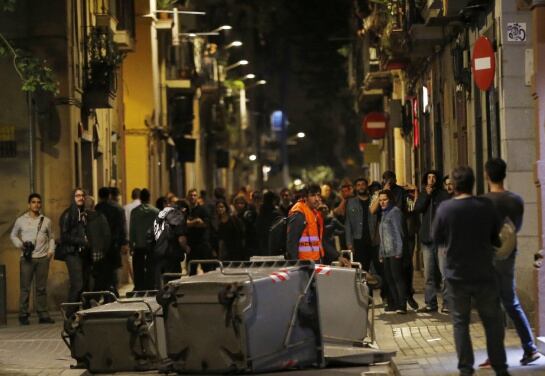 Varios manifestantes han bloqueado esta noche con contenedores calles del barrio barcelonés de Gracia