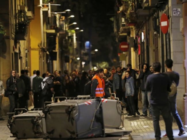 Varios manifestantes han bloqueado esta noche con contenedores calles del barrio barcelonés de Gracia