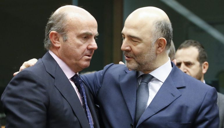 El ministro español de Economía, Luis de Guindos, conversa con el comisario europeo de Asuntos Económicos, Pierre Moscovici, durante una reunión en Bruselas, en enero del 2016.