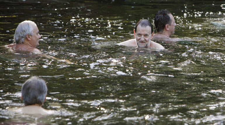 ***VERSIÓN AMPLIADA*** GRA119. MEIS (PONTEVEDRA), 26/07/2015.- Fotografía facilitada por La Voz de Galicia del presidente del Gobierno, Mariano Rajoy (2d), durante un baño con unos amigos que se dio ayer en las aguas del río Umia, en Meis (Pontevedra). El