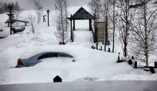 Un coche cubierto de nieve en un parque de Benasque