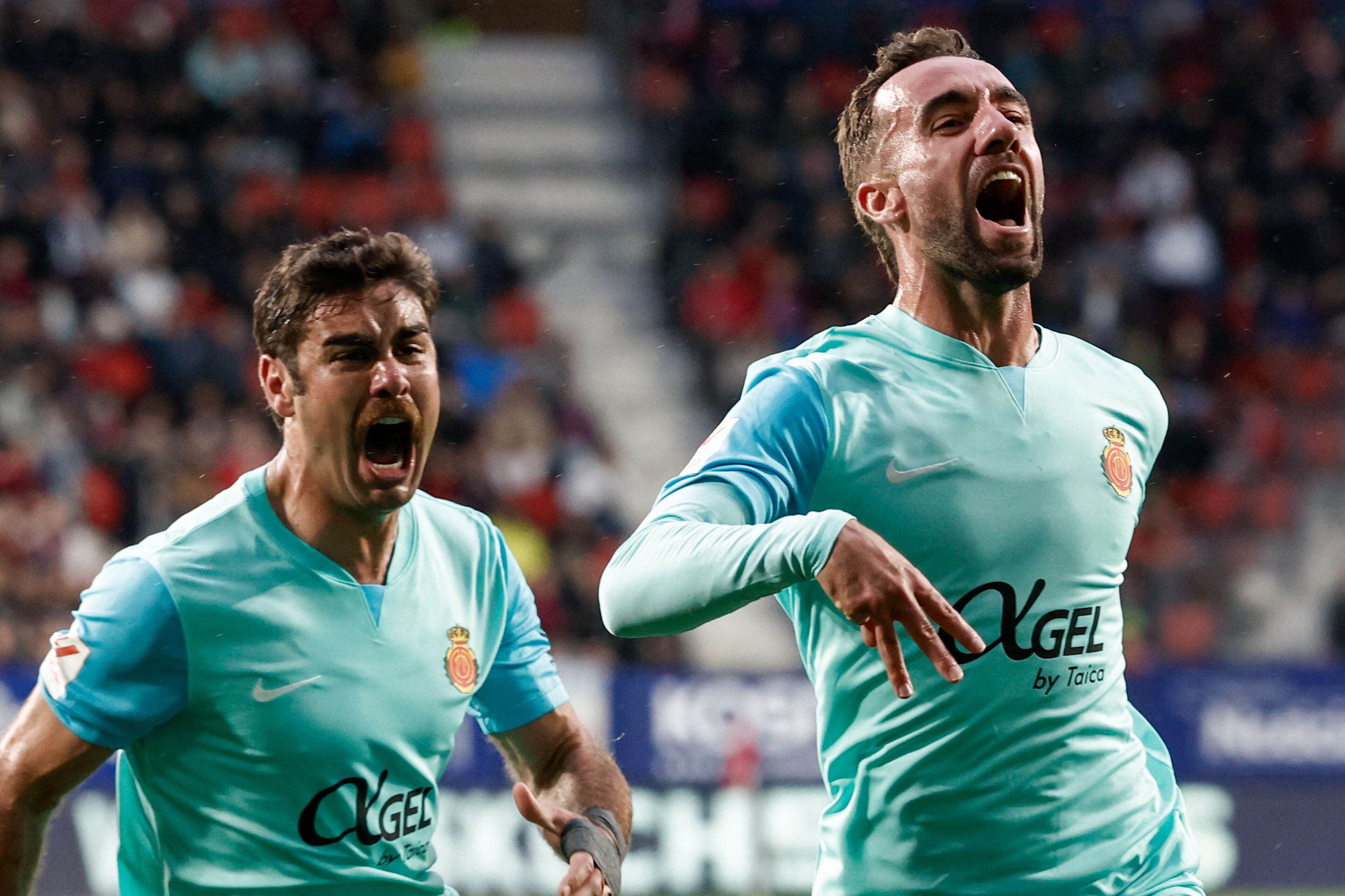 PAMPLONA, 14/05/2024.- El centrocampista del Mallorca Sergi Darder (d) celebra con su compañero Abdón Prats (i) tras marcar el gol del empate 1-1 durante el encuentro de la jornada 36 de LaLiga EA Sports entre CA Osasuna y RCD Mallorca, este martes en el Estadio El Sadar, en Pamplona. EFE/Jesús Diges
