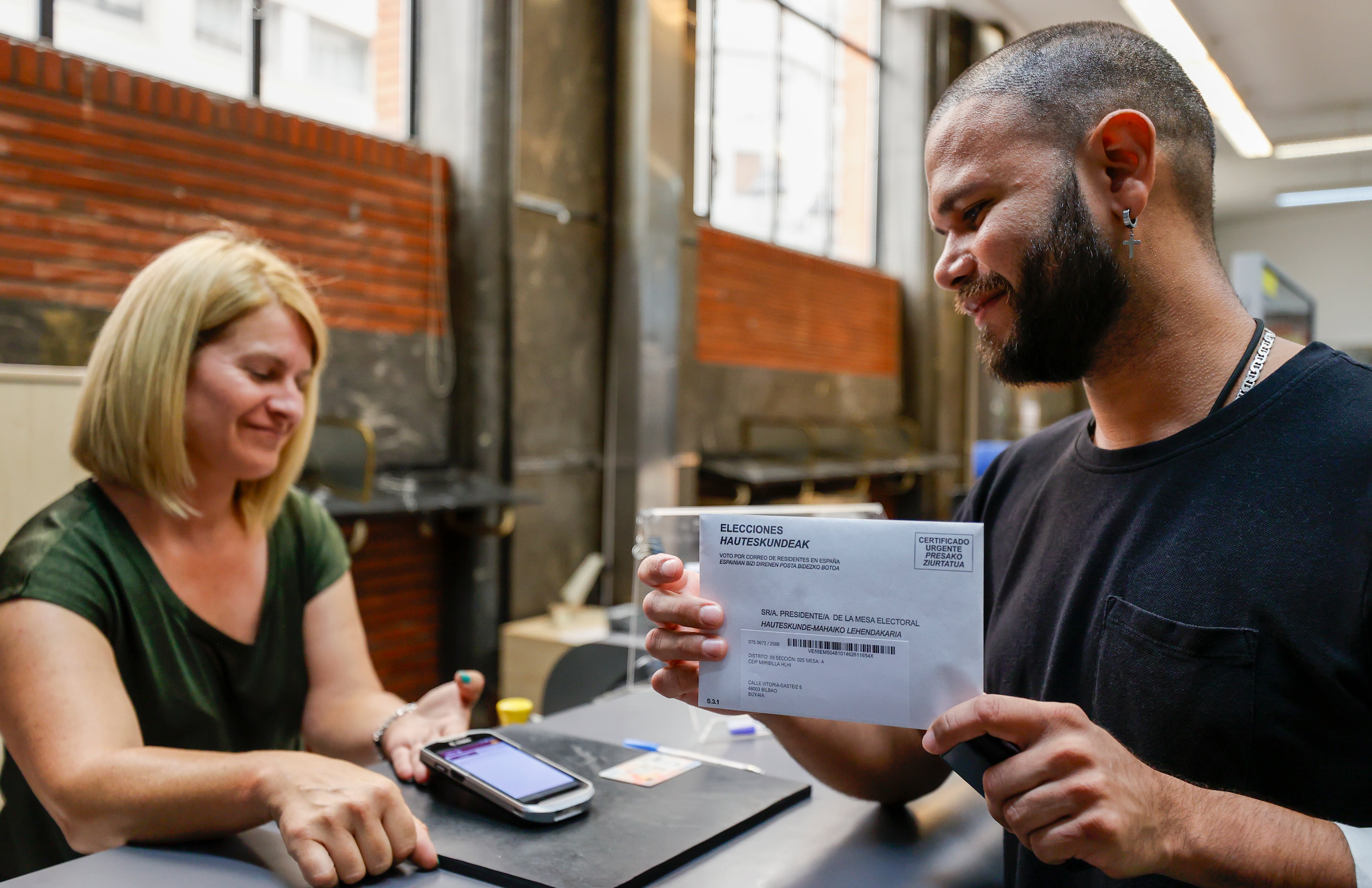 Un ciudadano realiza y firma el voto por correo.