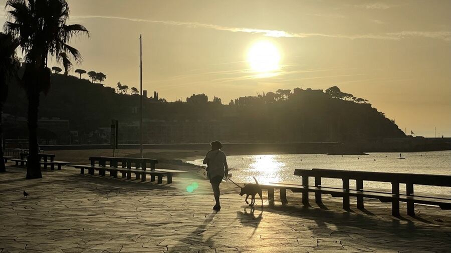 Dona passejant amb un gos a Blanes.