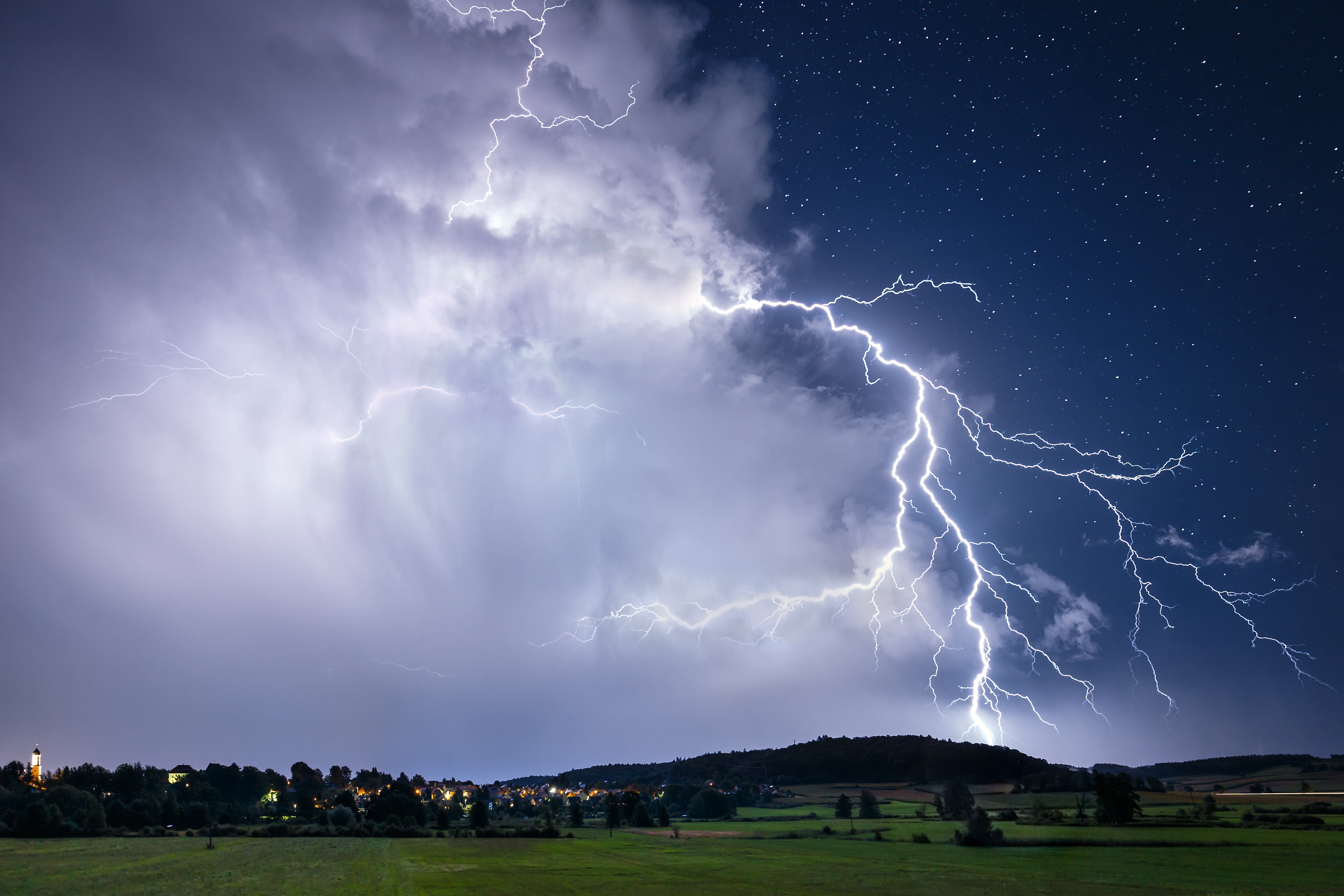 Un rayo sale de un conjunto de nubes en los cielos durante un día de tormenta (Imagen de archivo)