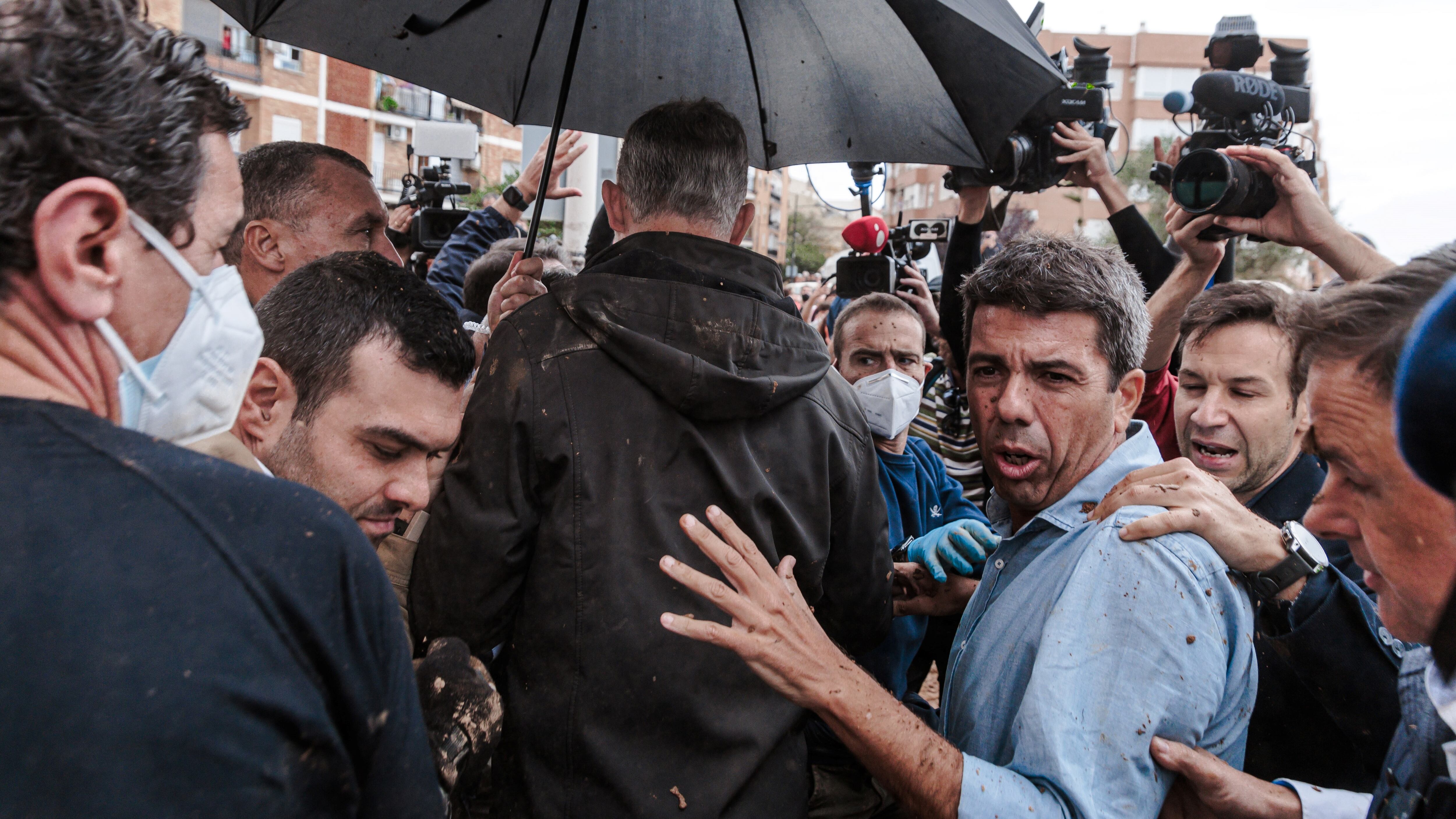 El presidente de la Generalitat, Carlos Mazón tras el rey de España, Felipe IV, durante su primera visita a Paiporta tras la DANA de octubre de 2024