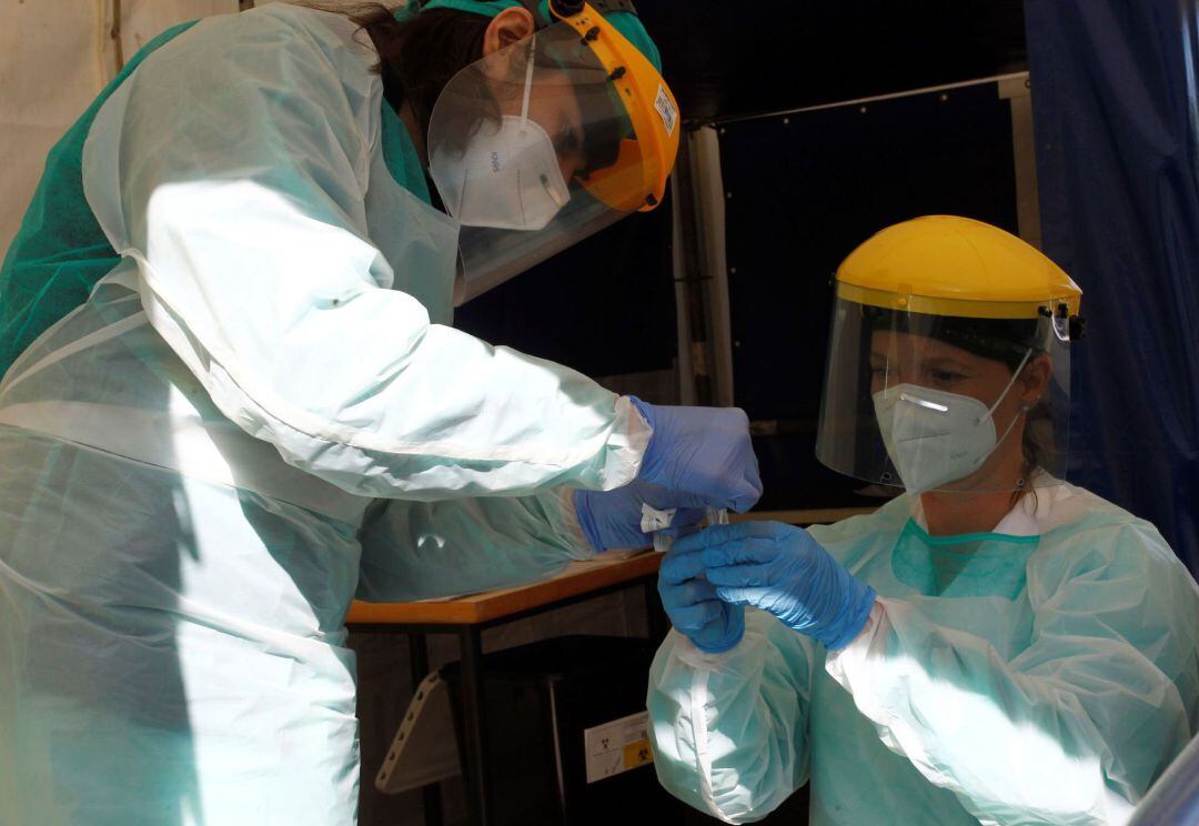 Dos profesionales sanitarios manejan test de Covid-19.