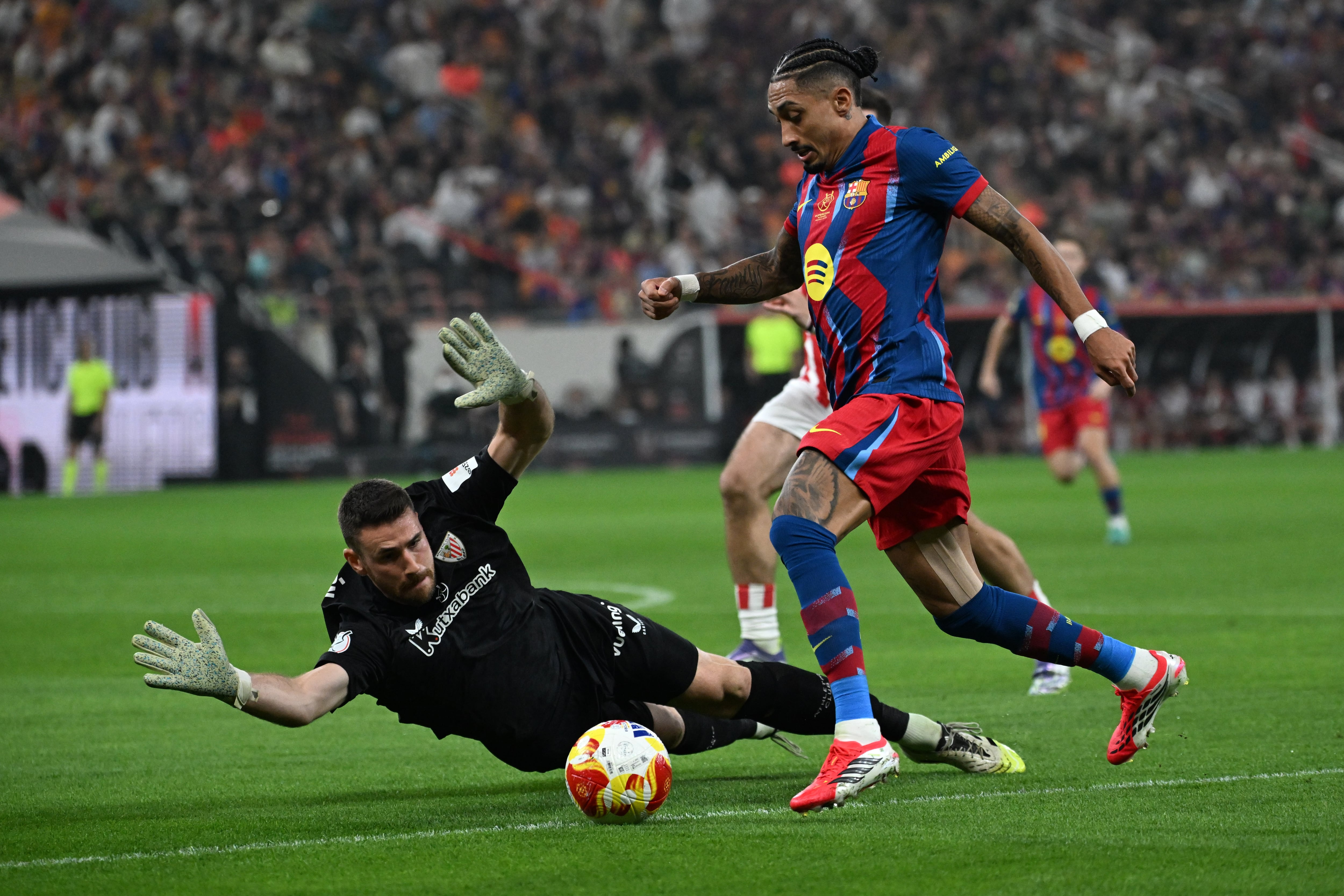 Jeddah (Saudi Arabia), 07/01/2026.- Raphinha of Barcelona (R) in action against goalkeeper Unai Simon of Athletic Club during the Spanish Super Cup semi final between Barcelona and Athletic Club in Jeddah, Saudi Arabia, 07 January 2026. (Arabia Saudita) EFE/EPA/STR