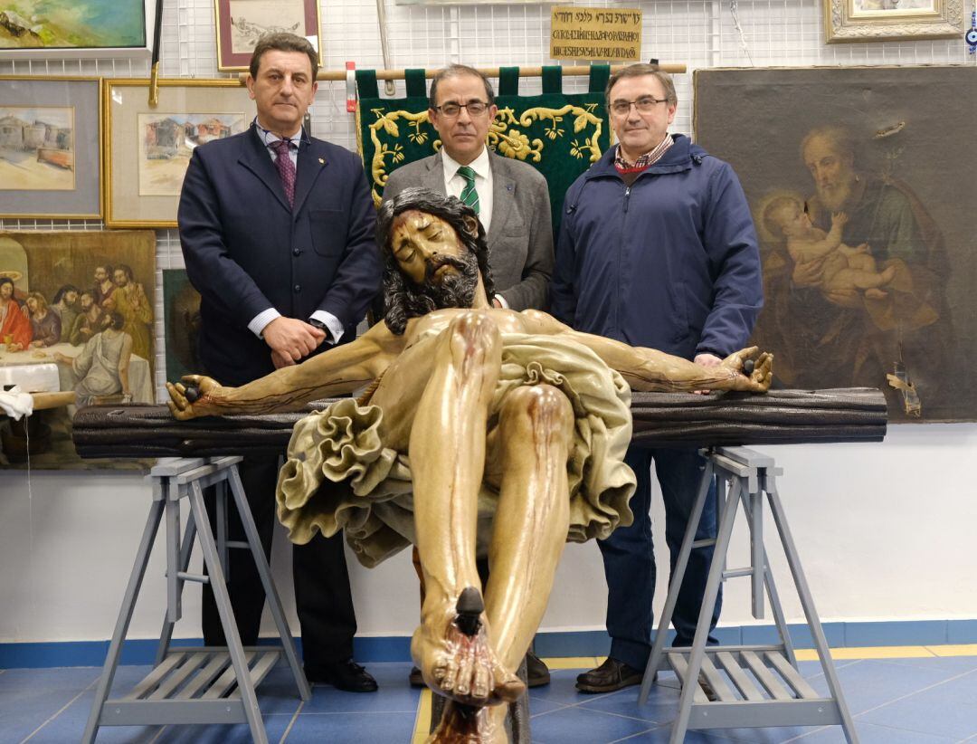 De izquierda a derecha, tras la imagen del Cristo de la Buena Muerte ya restaurada, el hermano mayor de Los Estudiantes, Jesús Resa; el rector de la Universidad de Sevilla, Miguel Ángel Castro; y Pedro Manzano