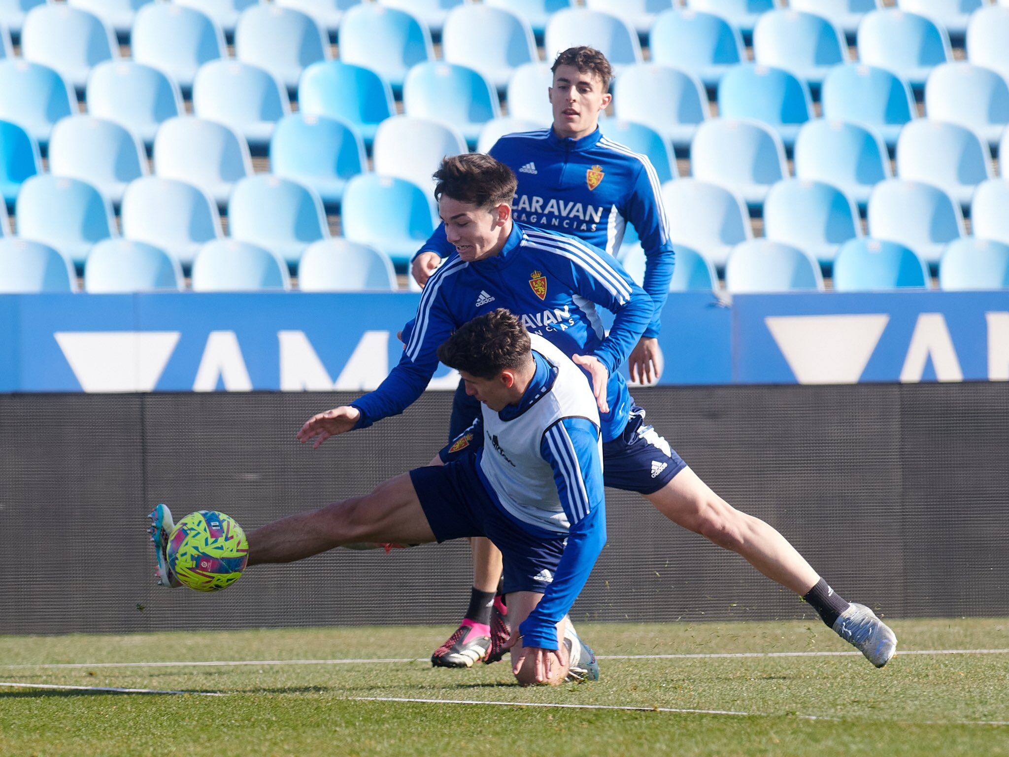 Pau Sans y Francés, que apuntan a titulares ante el Burgos, le disputan un balón a Giuliano Simeone