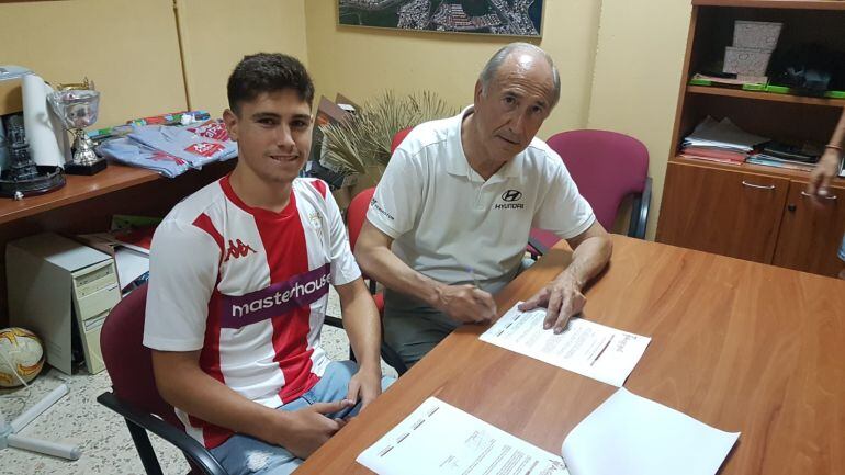 Alberto firma su contrato.