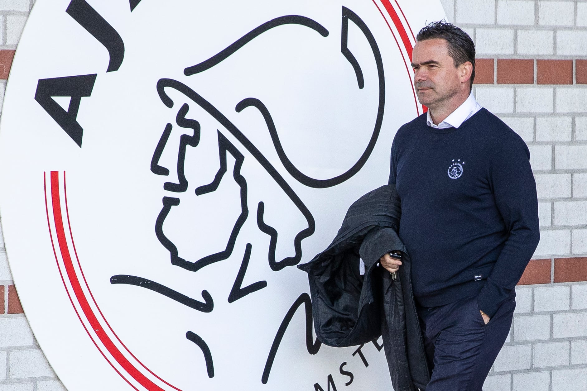 Marc Overmars pasa por delante de un escudo gigante del Ajax de Amsterdam