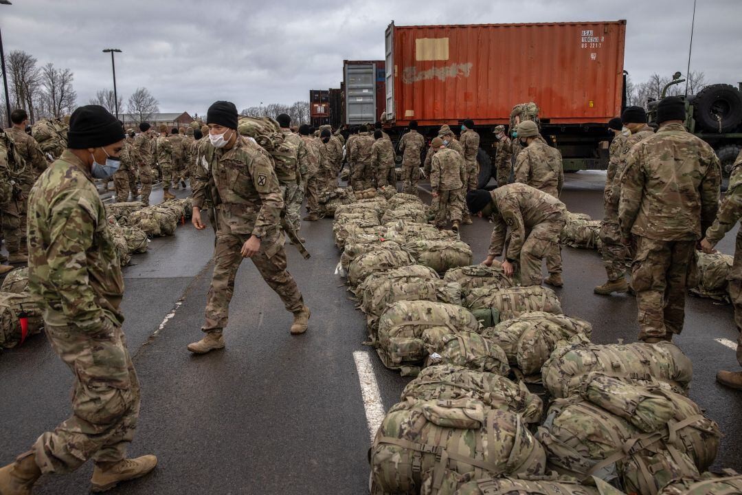 Los soldados del ejército de los EEUU recuperan sus bolsas de lona después de regresar a casa de un despliegue en Afganistán