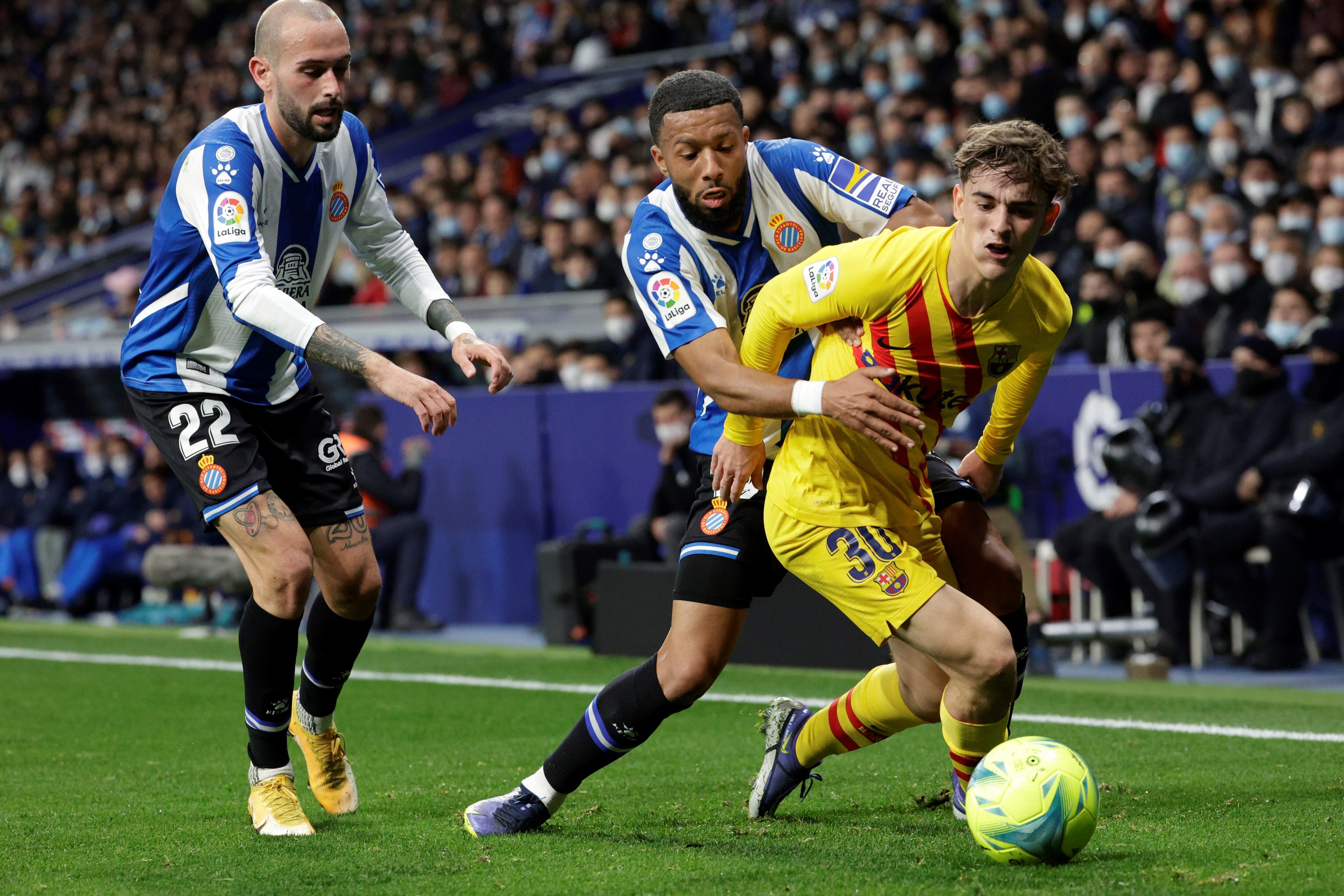 Gavi intenta llevarse el balón el centrocampista del Espanyol, Yangel Herrera, durante el partido de la jornada 24 de Liga en Primera División que se disputa hoy domingo en el RCDE Stadium, en Cornellà. EFE/Quique García.