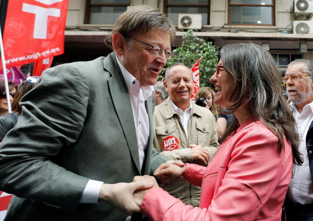 El presidente y la vicepresidenta de la Generalitat Valenciana, Ximo Puig y Mónica Oltra, se saludan al inicio de la manifestación del Primero de Mayo y en la que han aparecido en público por primera vez tras las elecciones del pasado 28A