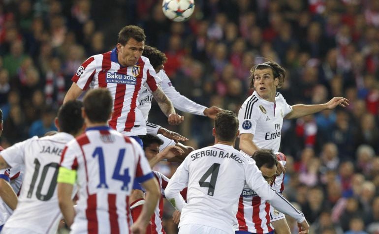 GRA548. MADRID, 14/04/2015.- El delantero croata del Atlético de Madrid Mario Mandzukic (i. arriba) salta por el balón con el galés Gareth Bale (d), del Real Madrid, durante el partido de ida de cuartos de final de Liga de Campeones que se disputa esta no