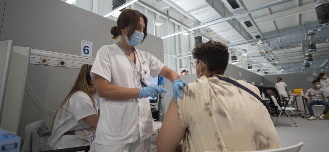 Un joven recibe la primera dosis de la vacuna en el Hospital Zendal