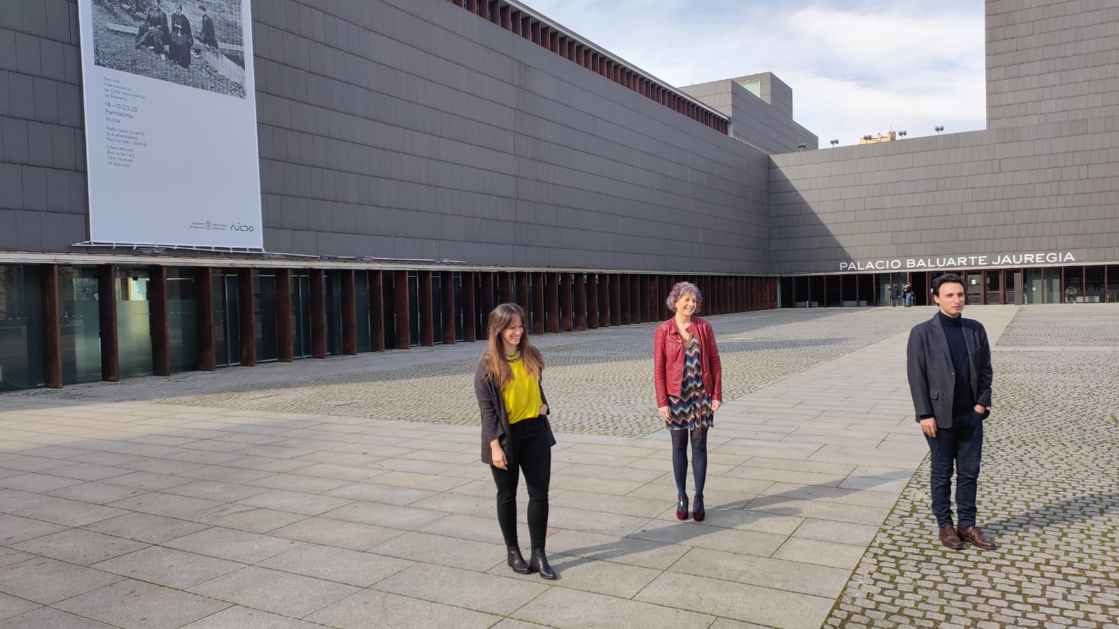 Teresa Morales de Álava, directora ejecutiva del Festival Punto de Vista 2022, Rebeca Esnaola, consejera de Cultura, y Manuel Asín, director artístico del Festival, posan ante el auditorio pamplonés Baluarte, escenario destacado donde se va a desarrollar gran parte de esta cita internacional con el cine documental.