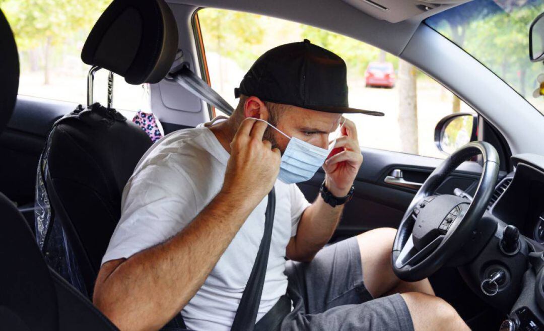 Un hombre se coloca una mascarilla.