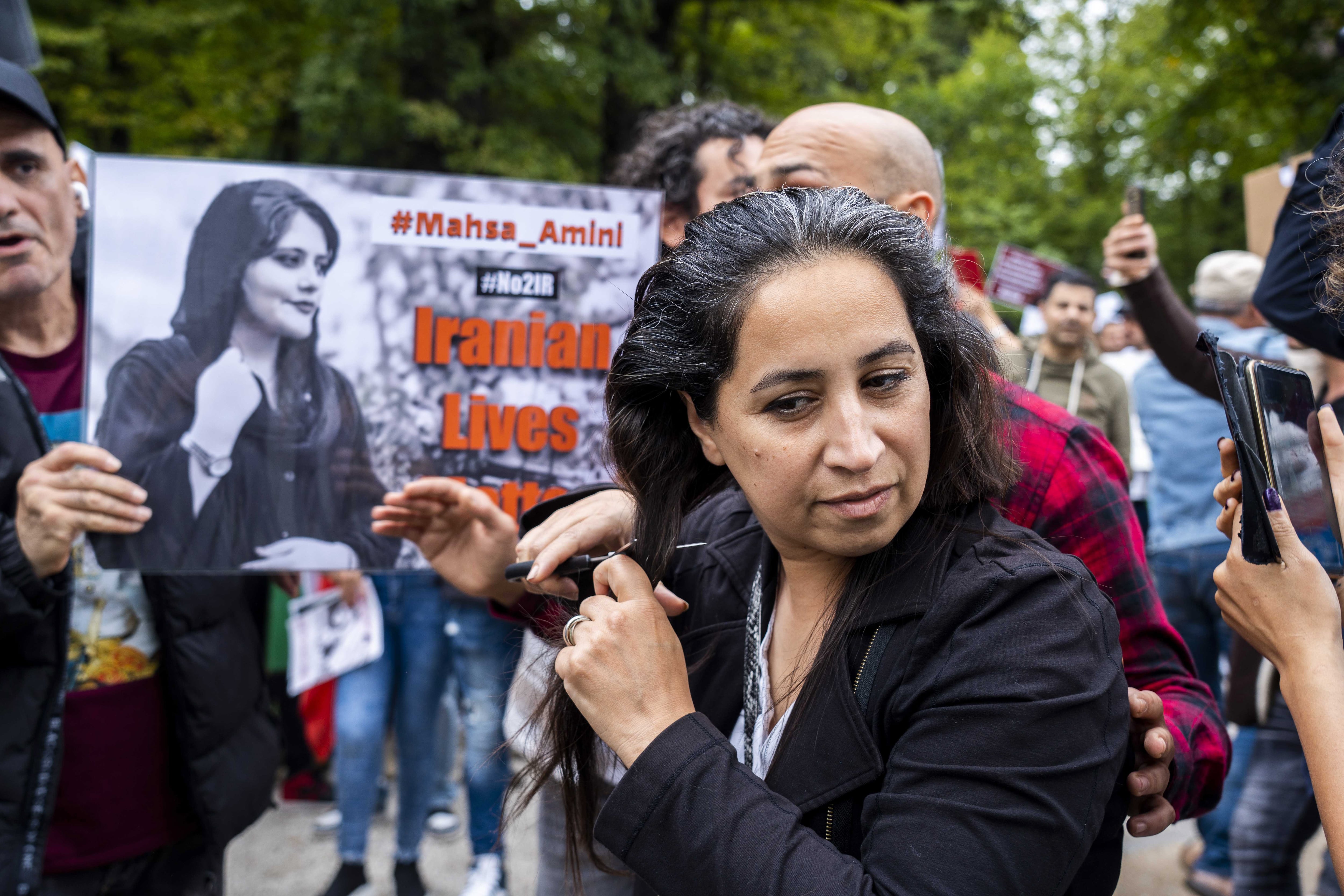 Una mujer irání se corta el pelo durante una manifestación por la muerte de Mahsa Amini.