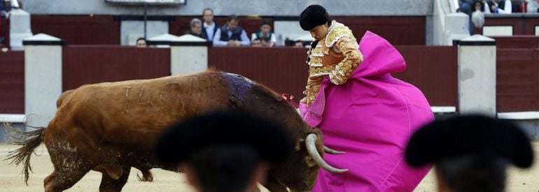 El diestro peruano Roca Rey da un pase con el capote a su segundo toro durante la corrida de la Feria de San Isidro