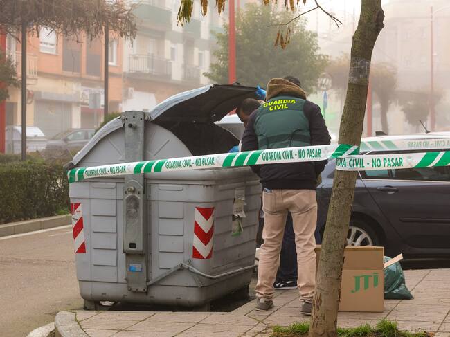 Agentes de la Guardia Civil inspeccionan un contenedor frente al edificio en el que una mujer de unos 50 años de edad ha sido hallada muerta, en el interior de su domicilio, este jueves en Santa Marta de Tormes, Salamanca.