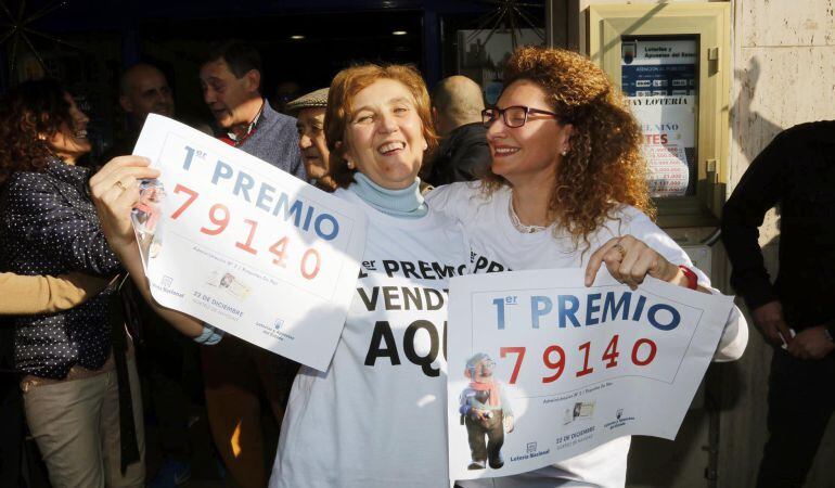 Unas mujeres se felicitan con las copias del número 79.140, agraciado con el Gordo de Navidad del Sorteo Extraordinario de la Loteria celebrado hoy y vendido íntegramente en la administracion nº 2 de Roquetas de Mar (Almería)