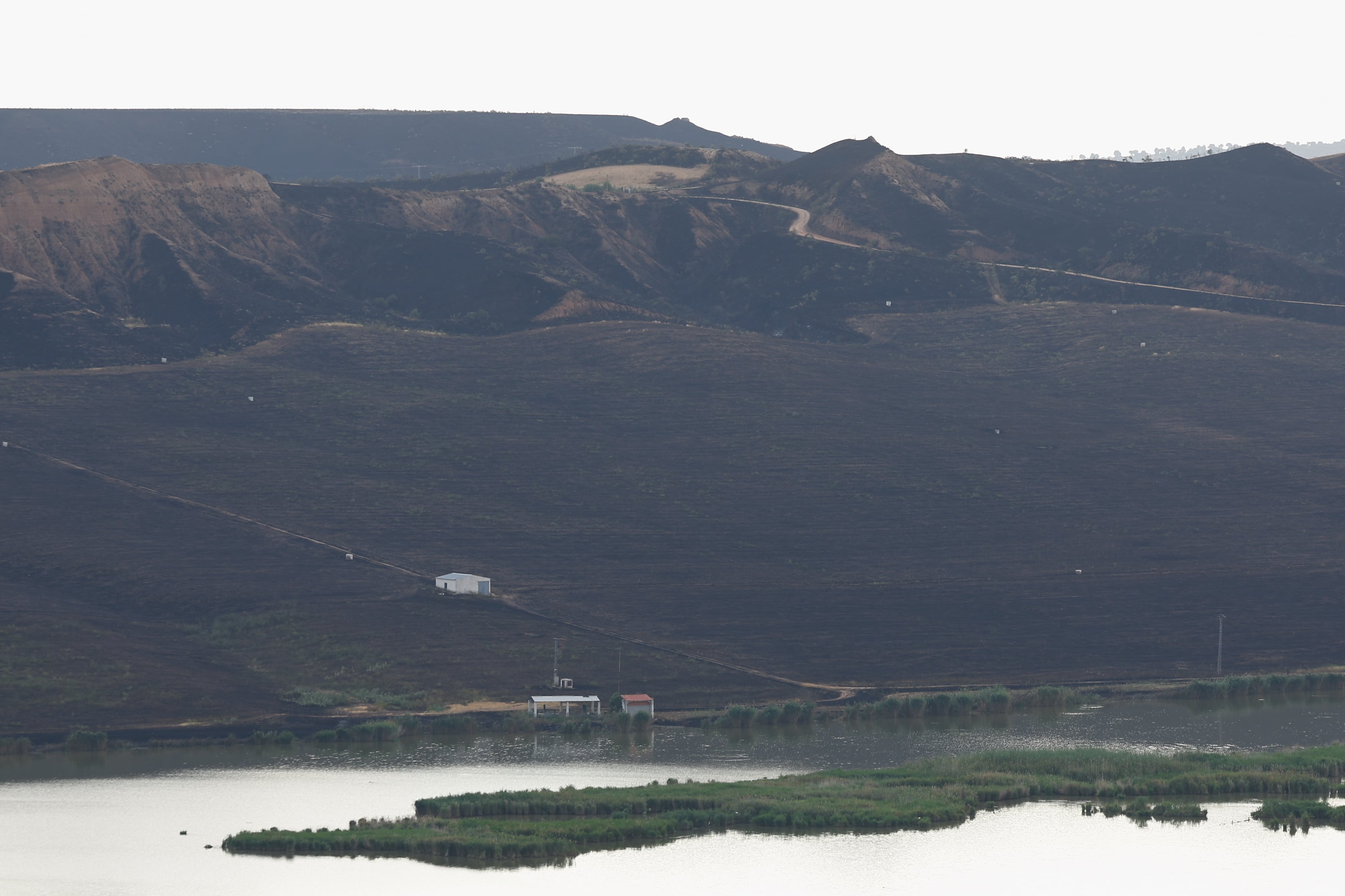 TOLEDO, 17/06/2025.- El servicio de Prevención y Extinción de Incendios Forestales de Castilla-La Mancha ha dado este martes por controlado el incendio forestal que se originó ayer, lunes, por la tarde en las Barrancas de Burujón (Toledo) y que obligó a desalojar a 33 personas de una urbanización próxima, si bien los vecinos ya han podido regresar a sus casas. EFE/Ismael Herrero
