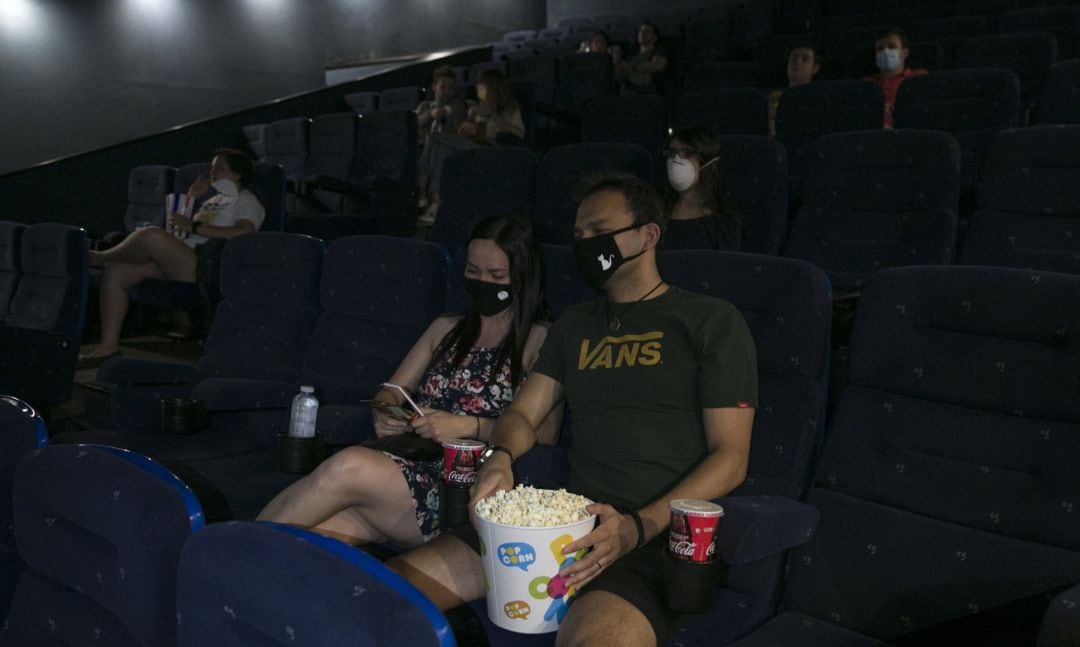 Varias personas en una sala de cine después de su reapertura.