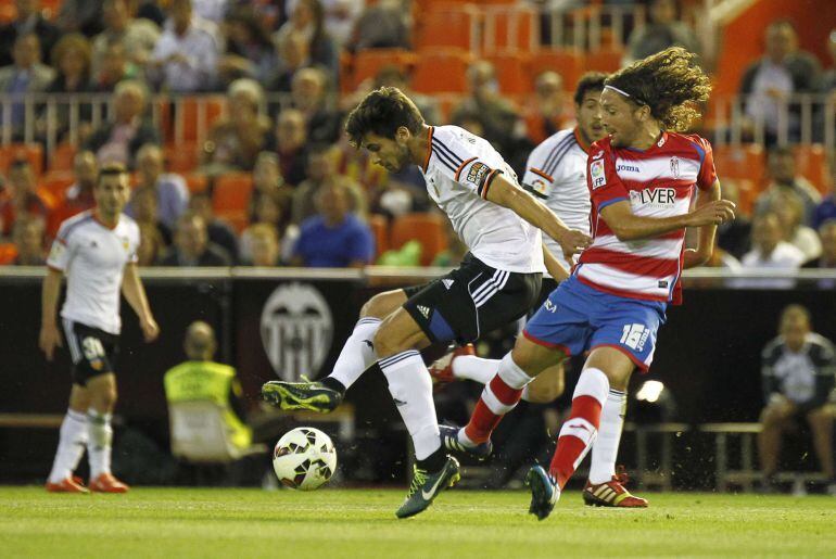 Valencia&#039;s Portuguese midfielder Andre Gomes (L) vies with Granada&#039;s Chilean midfielder Manuel Rolando Iturra during the Spanish league football match Valencia CF vs Granada FC at the Mestalla stadium in Valencia on April 27, 2015.  AFP PHOTO/ JOSE JORDAN