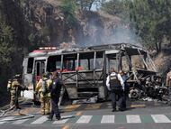 Bomberos e integrantes de la policía de Morelia trabajan en la zona donde fue incendiado un autobús por presuntos integrantes del crimen organizado este domingo
