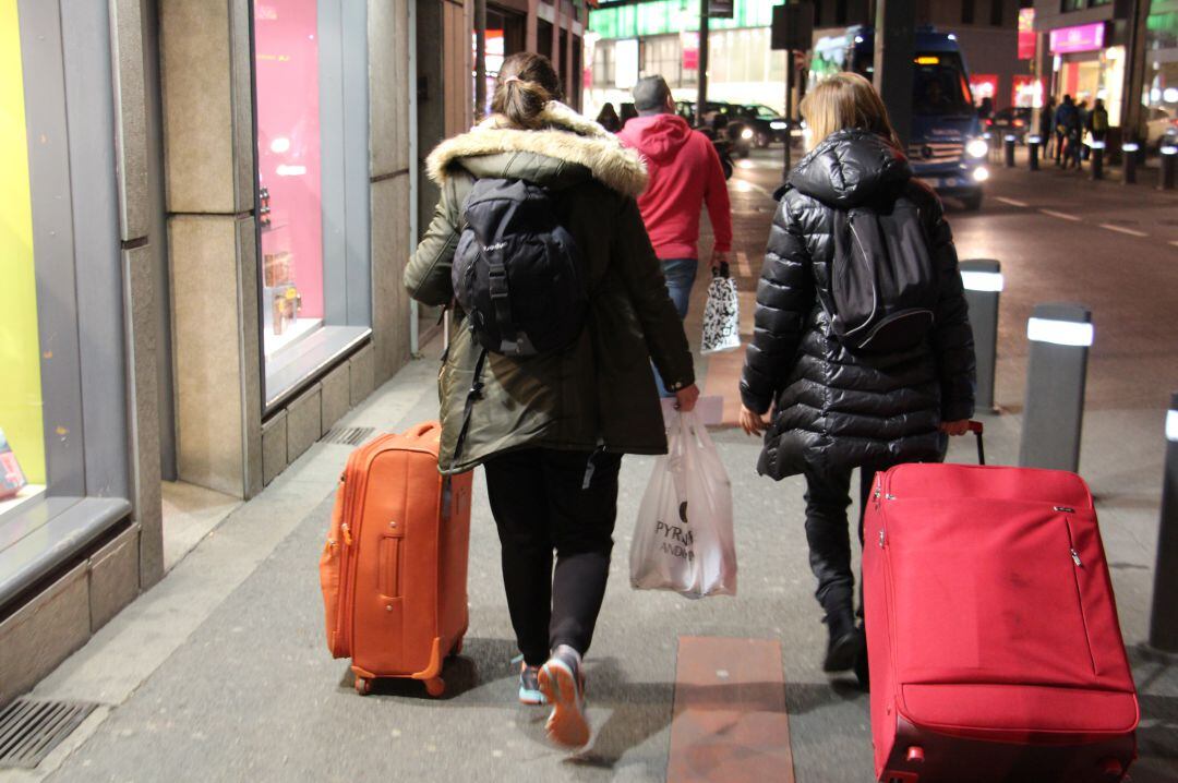 Turistes caminen per una de les principals arteries comercials del país, l'Av. Meritxell