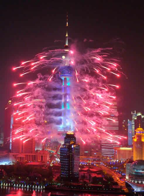 Fuegos artificiales sobre la torre de televisión <i> Perla de Oriente</i> de 457 metros de altura en el distrito de Pudong