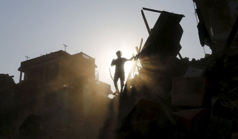 A Nepal army soldier stands inside a collapsed house as they search for belongings in Sankhu on the outskirts of Kathmandu, Nepal May 6, 2015.  REUTERS/Adnan Abidi