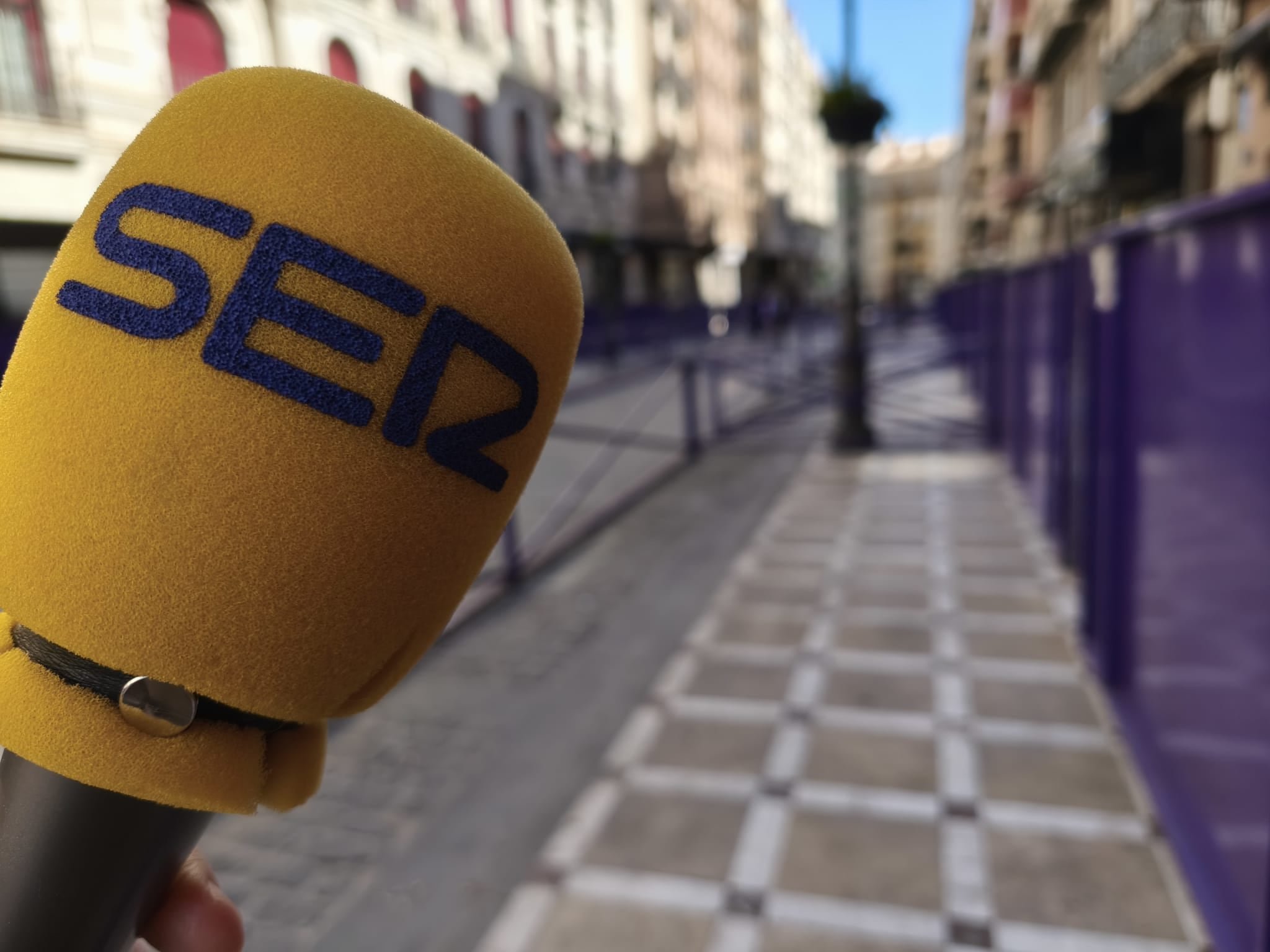 Micrófono de la SER en primer plano, con la carrera oficial de Jaén de fondo.