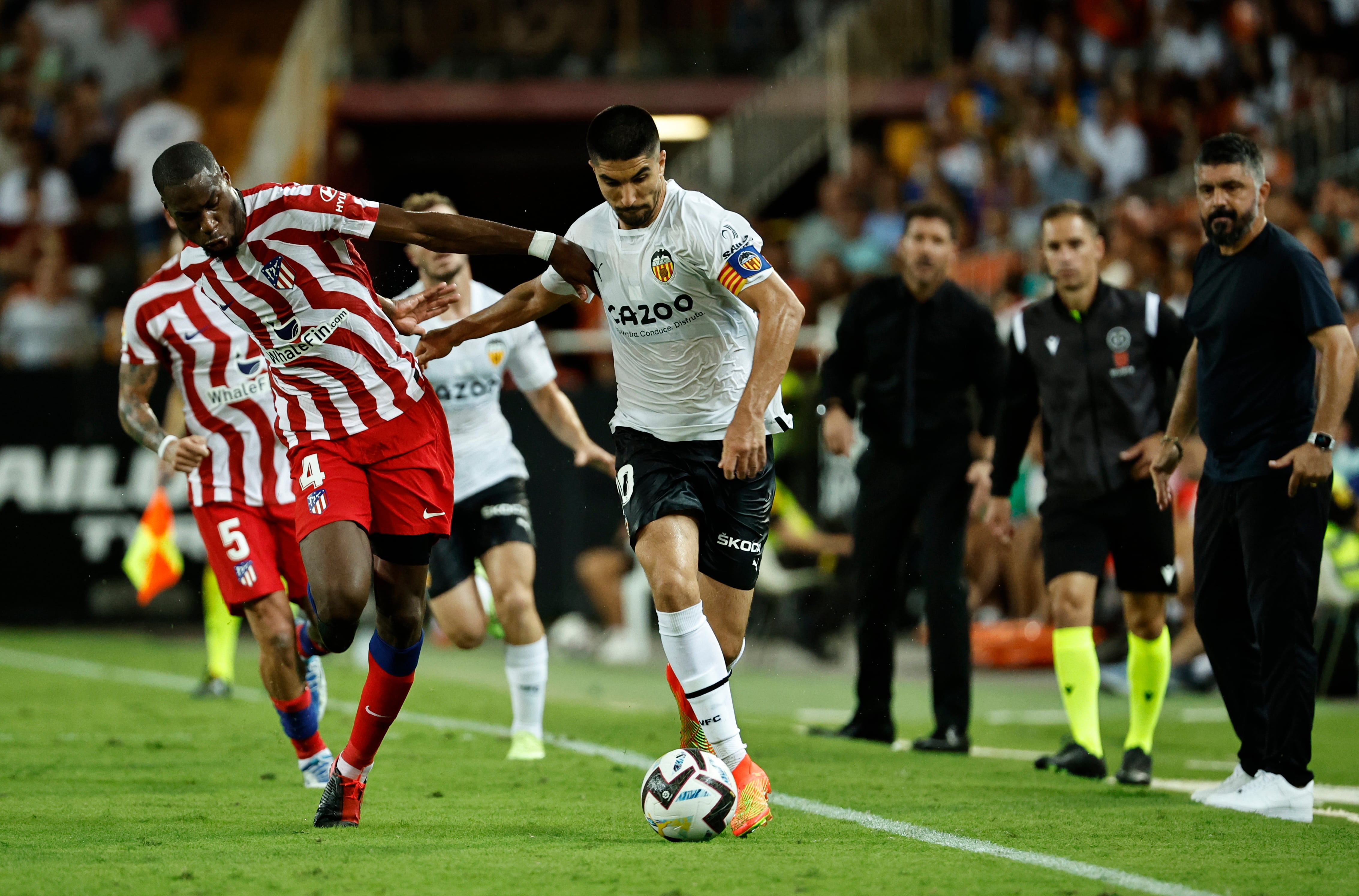 VALENCIA, 29/08/2022.- El centrocampista del Valencia CF Carlos Soler (d) se escapa del francés Geoffrey Kondogbia, del Atlético de Madrid, durante el partido de la tercera jornada de Liga en Primera División que Valencia CF y Atlético de Madrid disputan hoy lunes en el estadio de Mestalla. EFE/Biel Aliño
