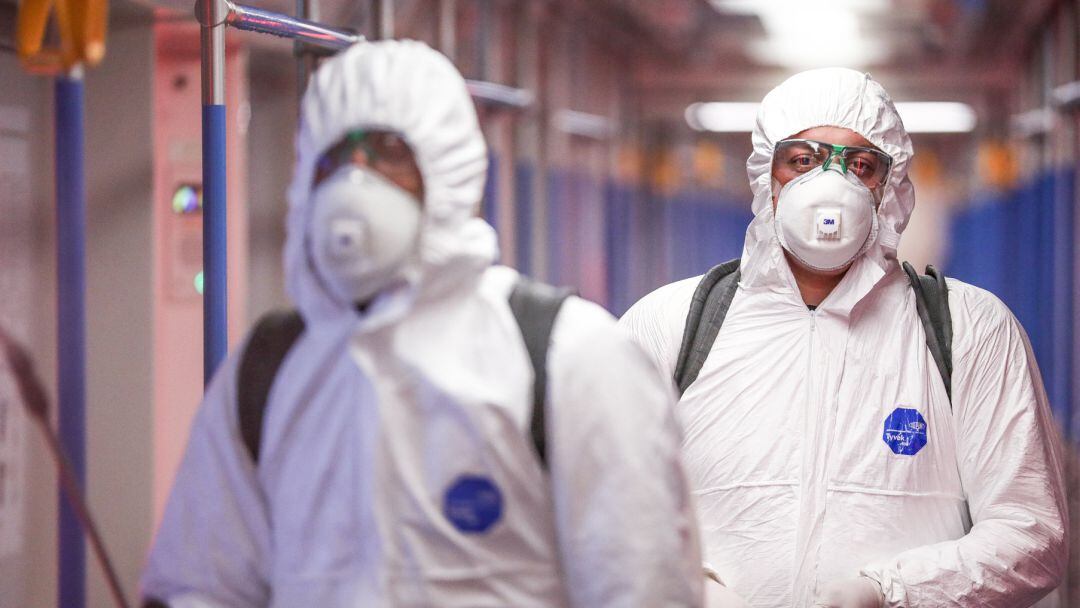 Dos personas desinfectan un vagón.